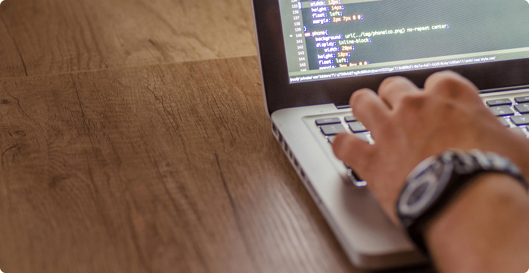 a MacBook Pro with a typing hand